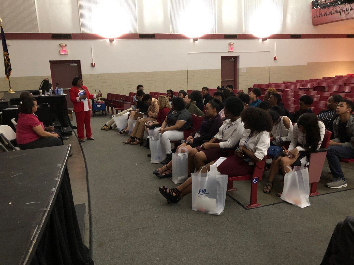 A woman is giving a presentation to a group of people in an auditorium