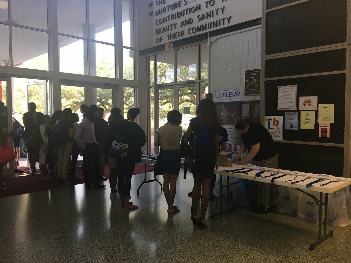 A group of people are standing around a table in a hallway.