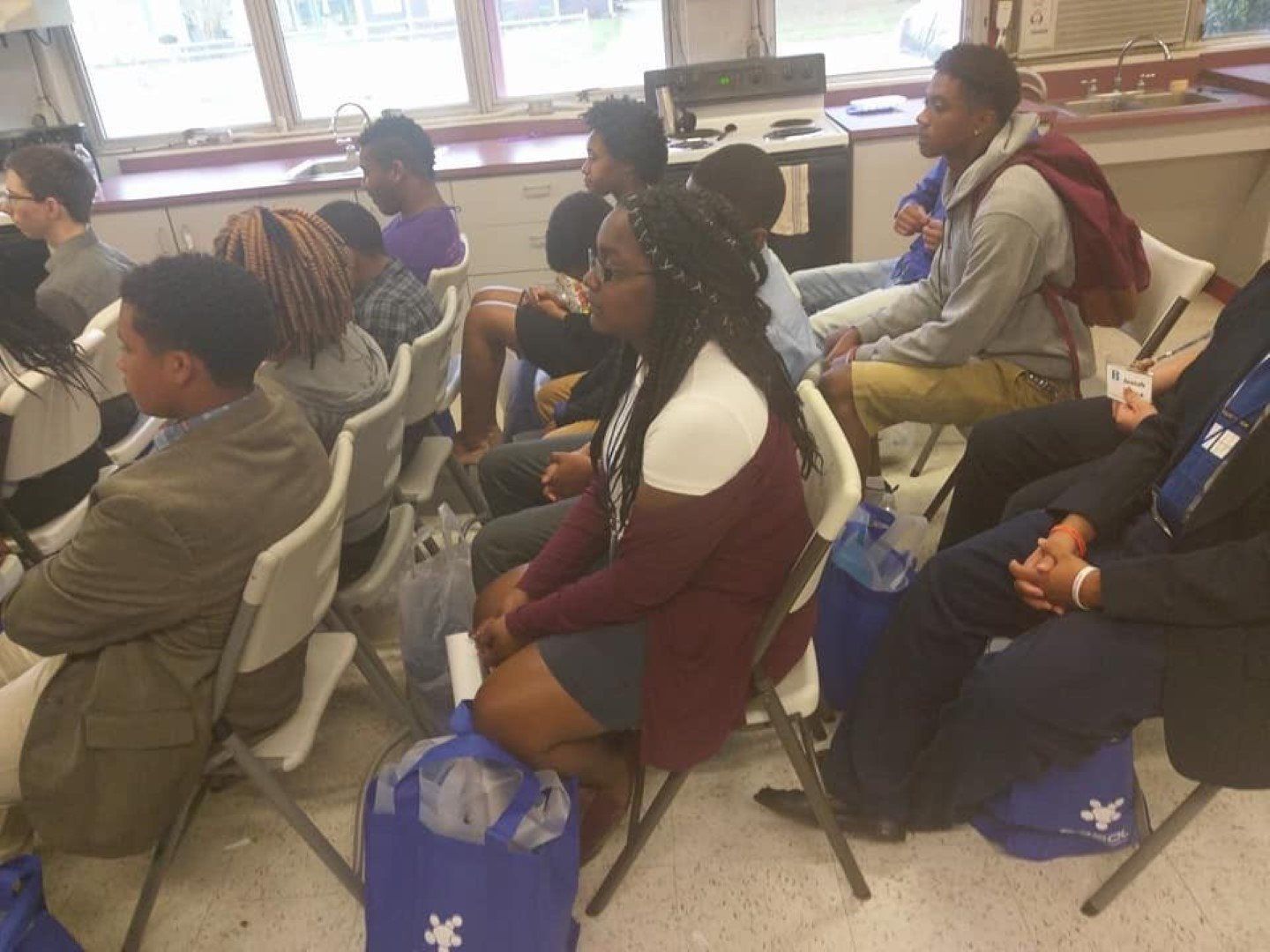 A group of people are sitting in chairs in a room.