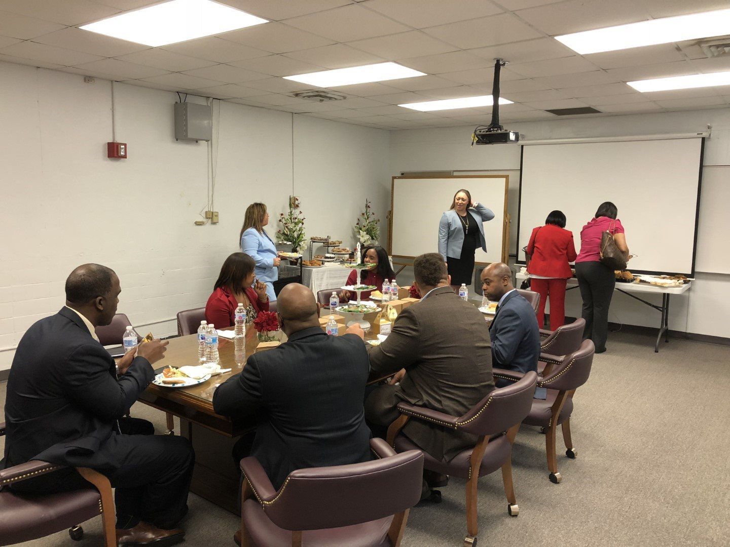 A group of people are sitting around a table in a conference room.