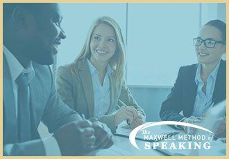 A group of business people are sitting around a table having a meeting.