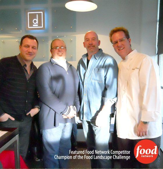 A group of men standing in front of a sign that says featured food network competitor champion