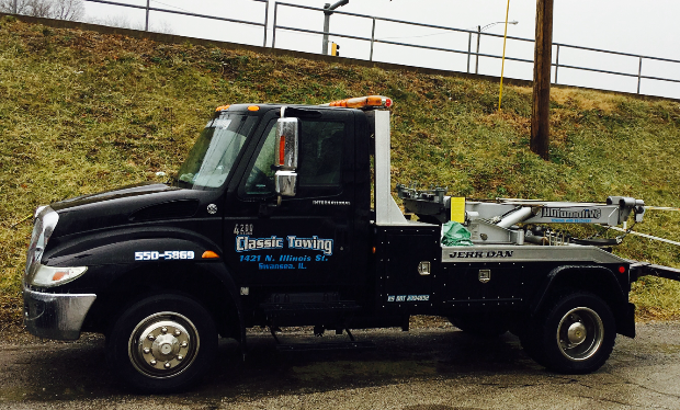 Black tow truck parked on a roadside, with “Classic Towing” on the door