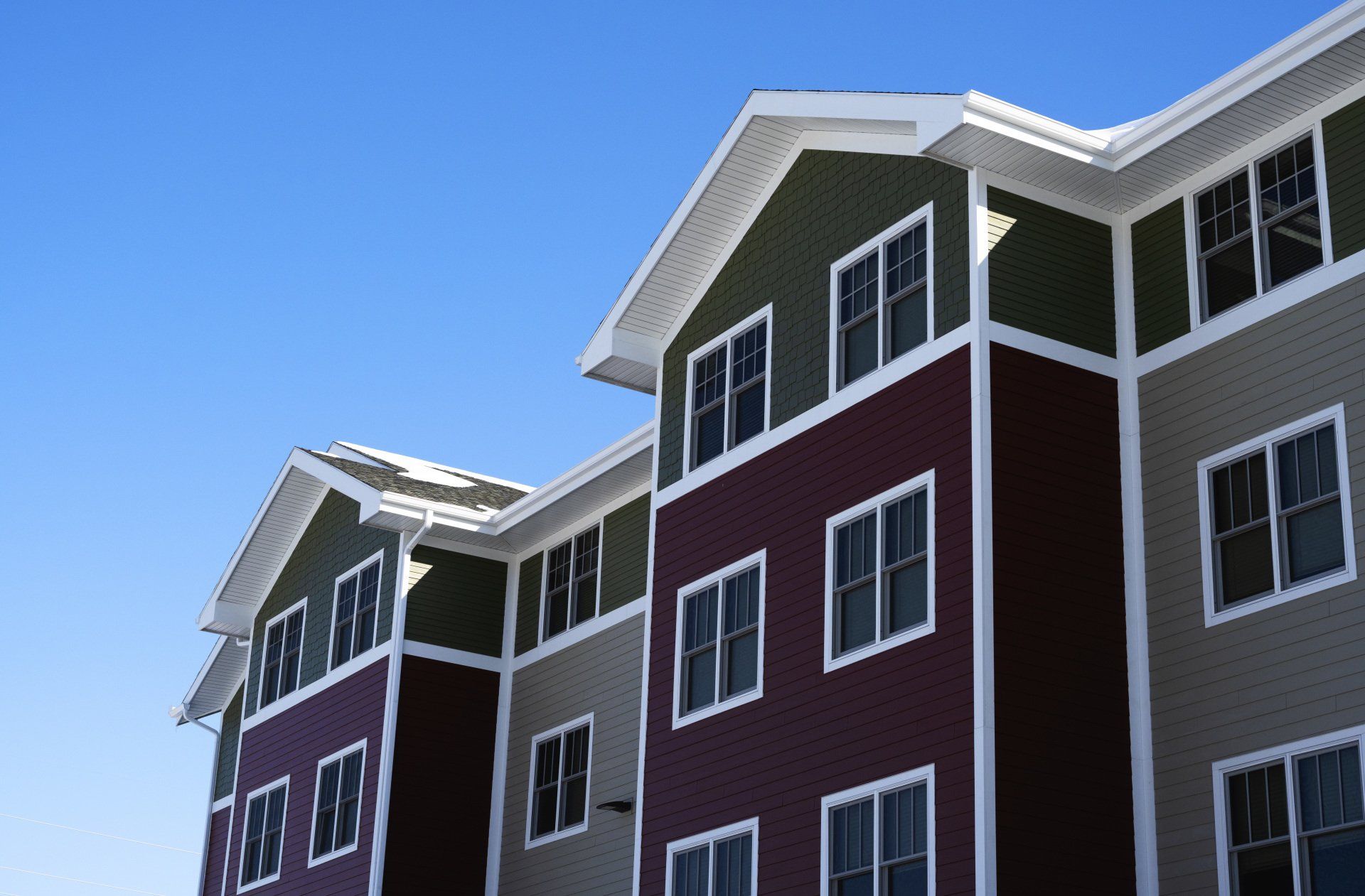 a large apartment building with a blue sky in the background