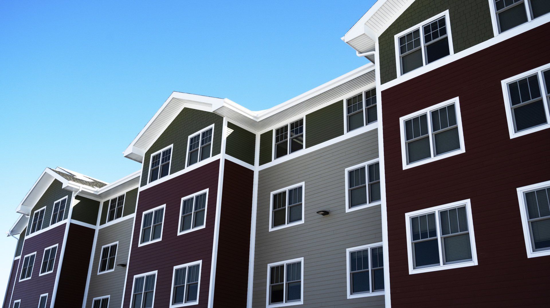 a row of apartment buildings with a blue sky in the background