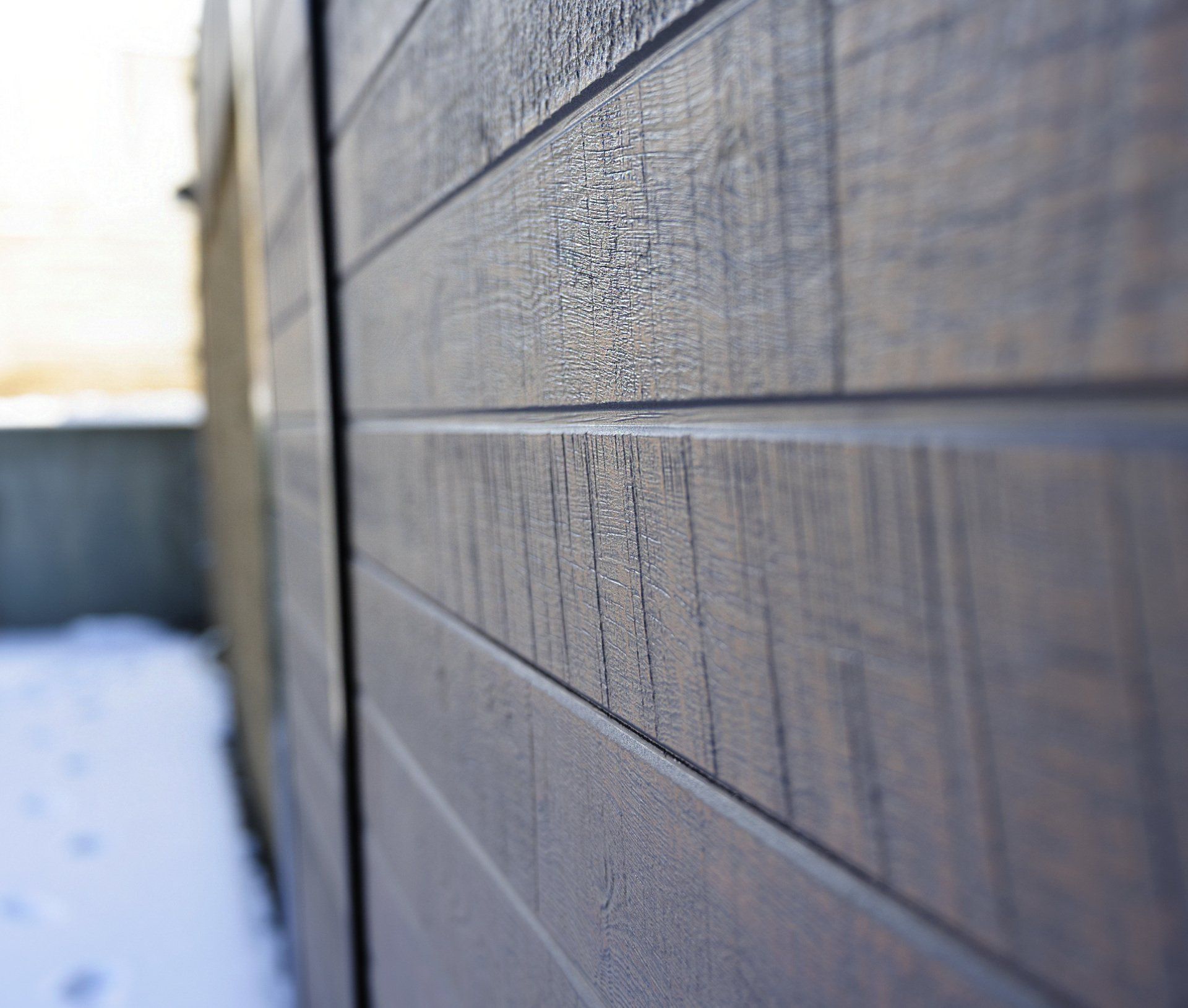 a close up of a wooden wall with snow in the background