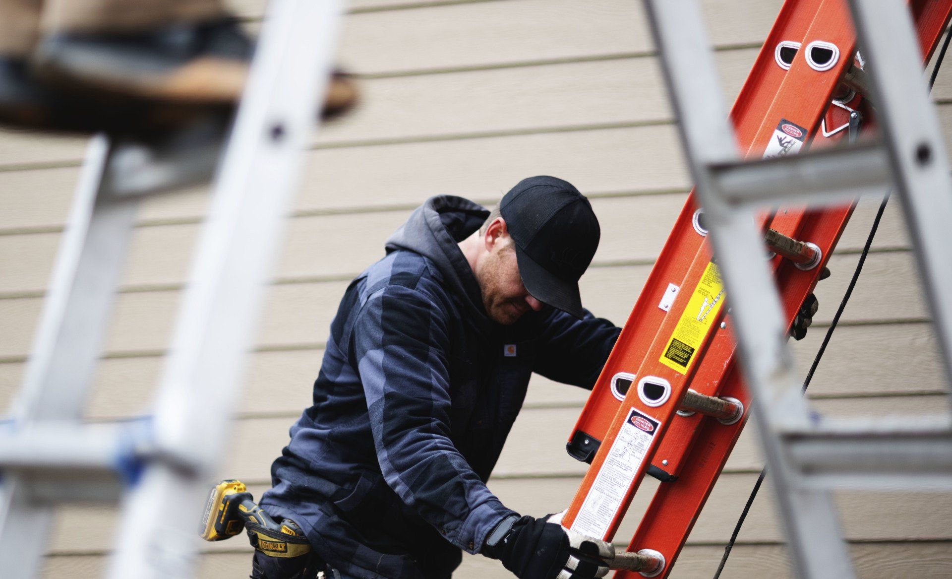 a man is climbing a ladder on a house .
