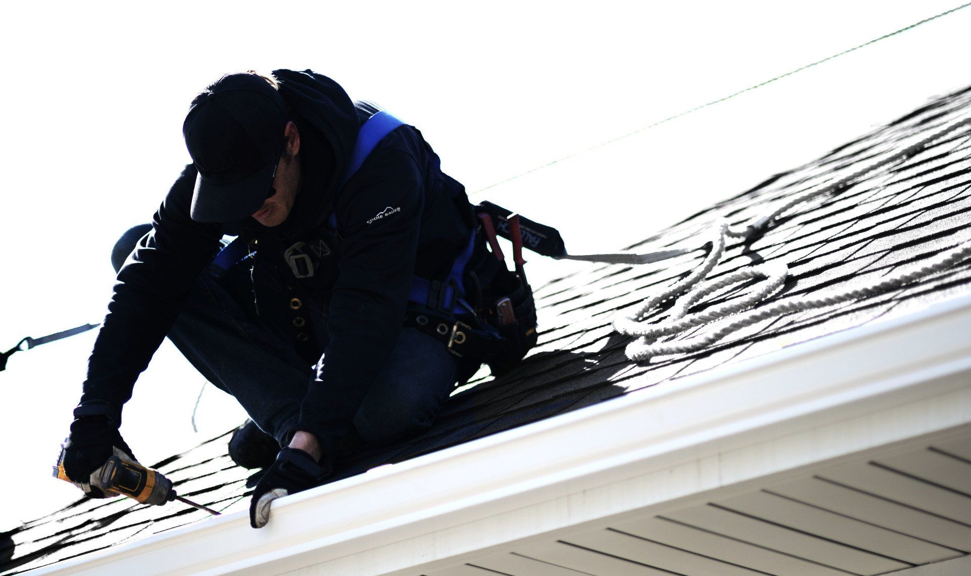 a man is working on the roof of a house .