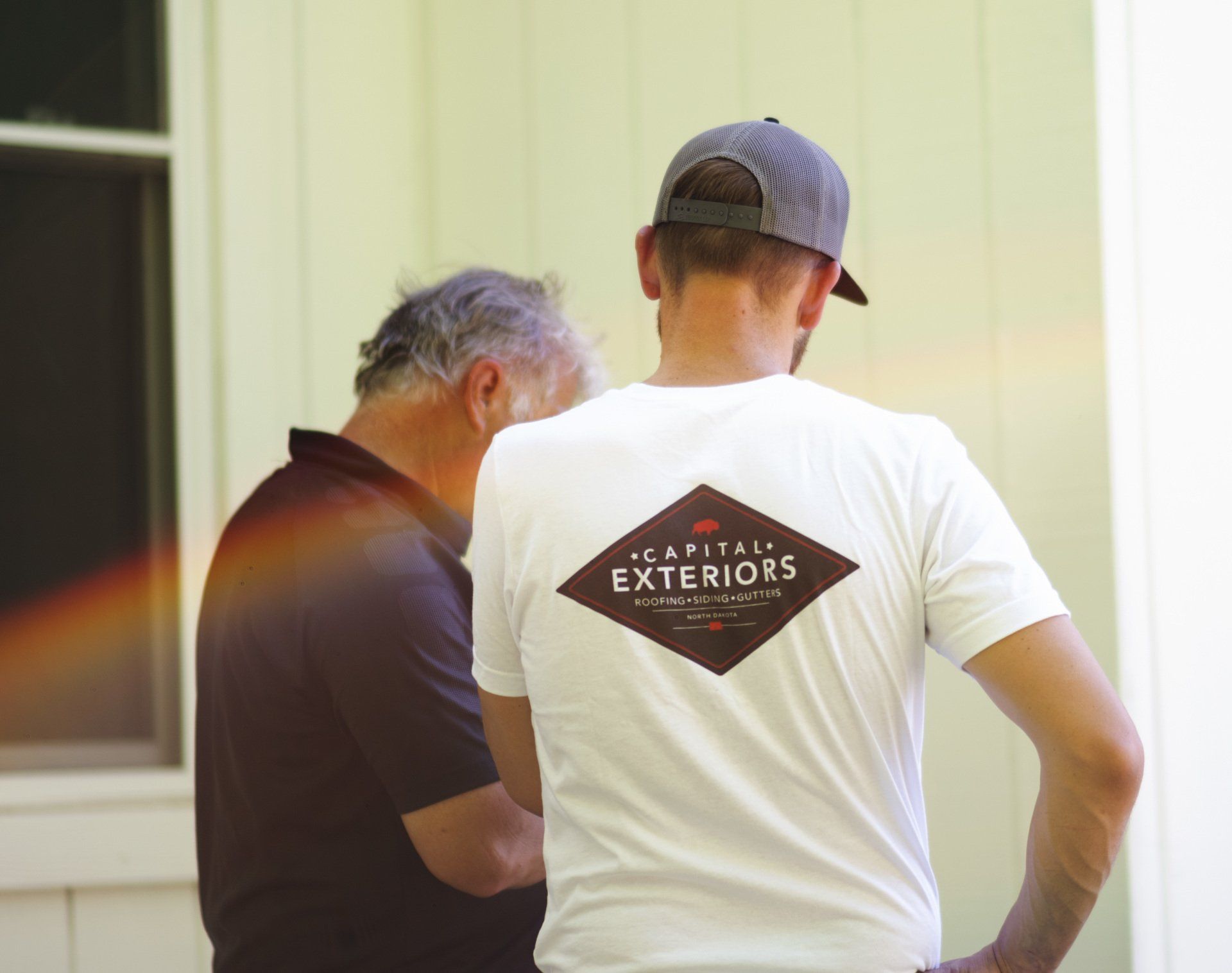 a man wearing a white shirt that says exteriors on it
