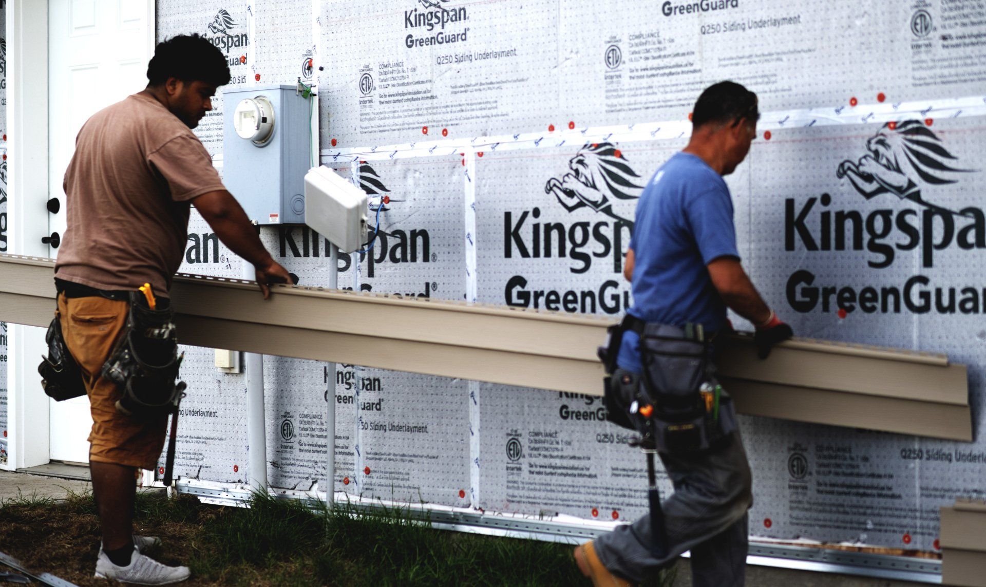 2 people working on house exterior