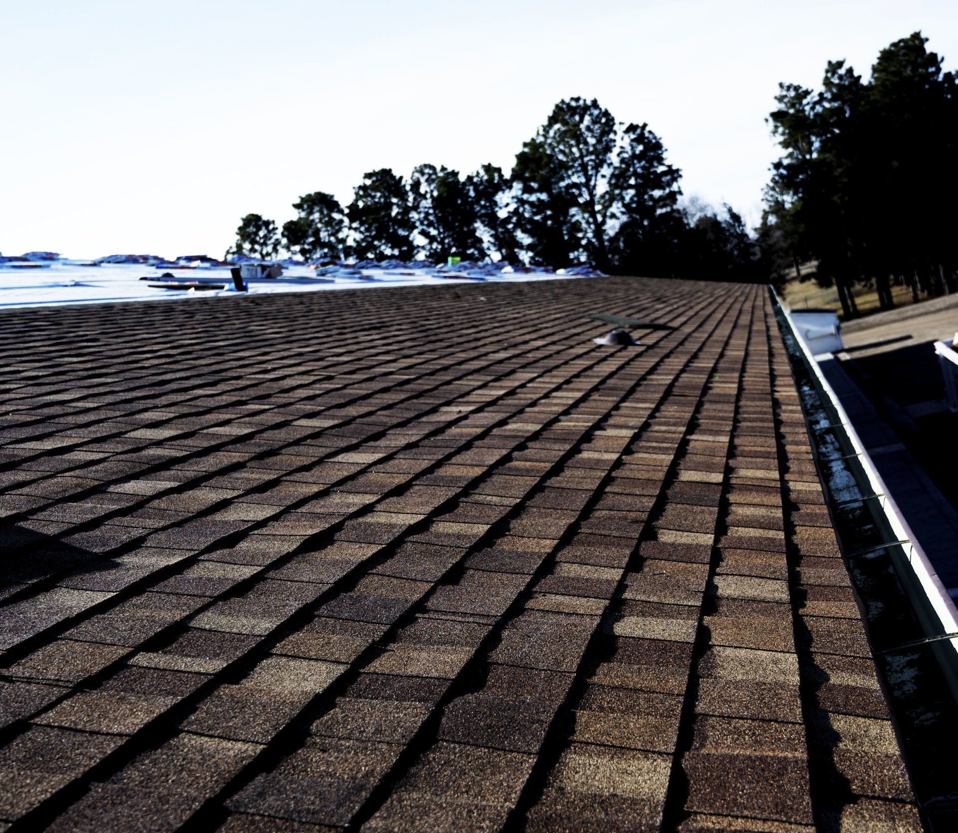 a roof with a drain and trees in the background