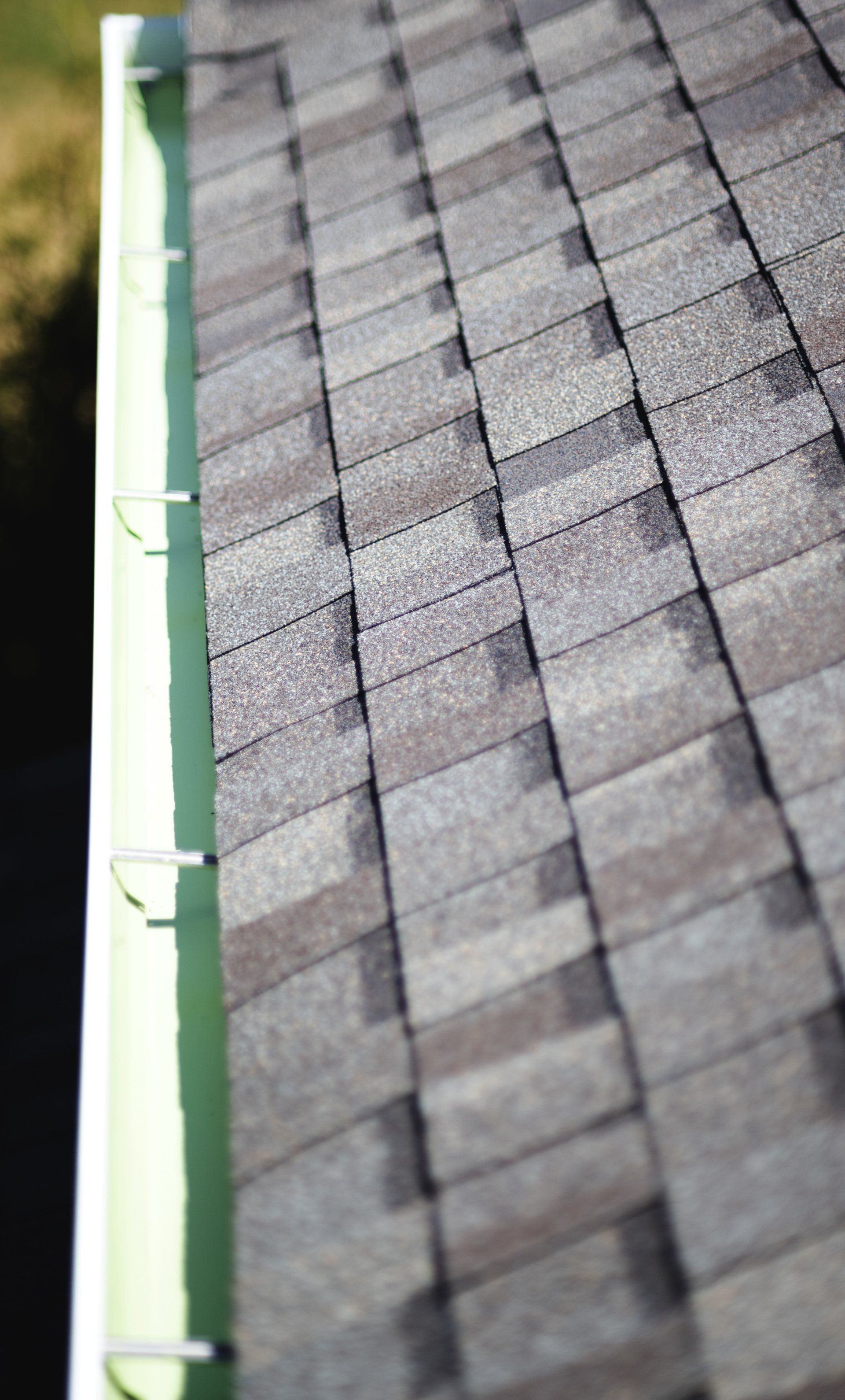 a close up of a roof with shingles and a gutter .