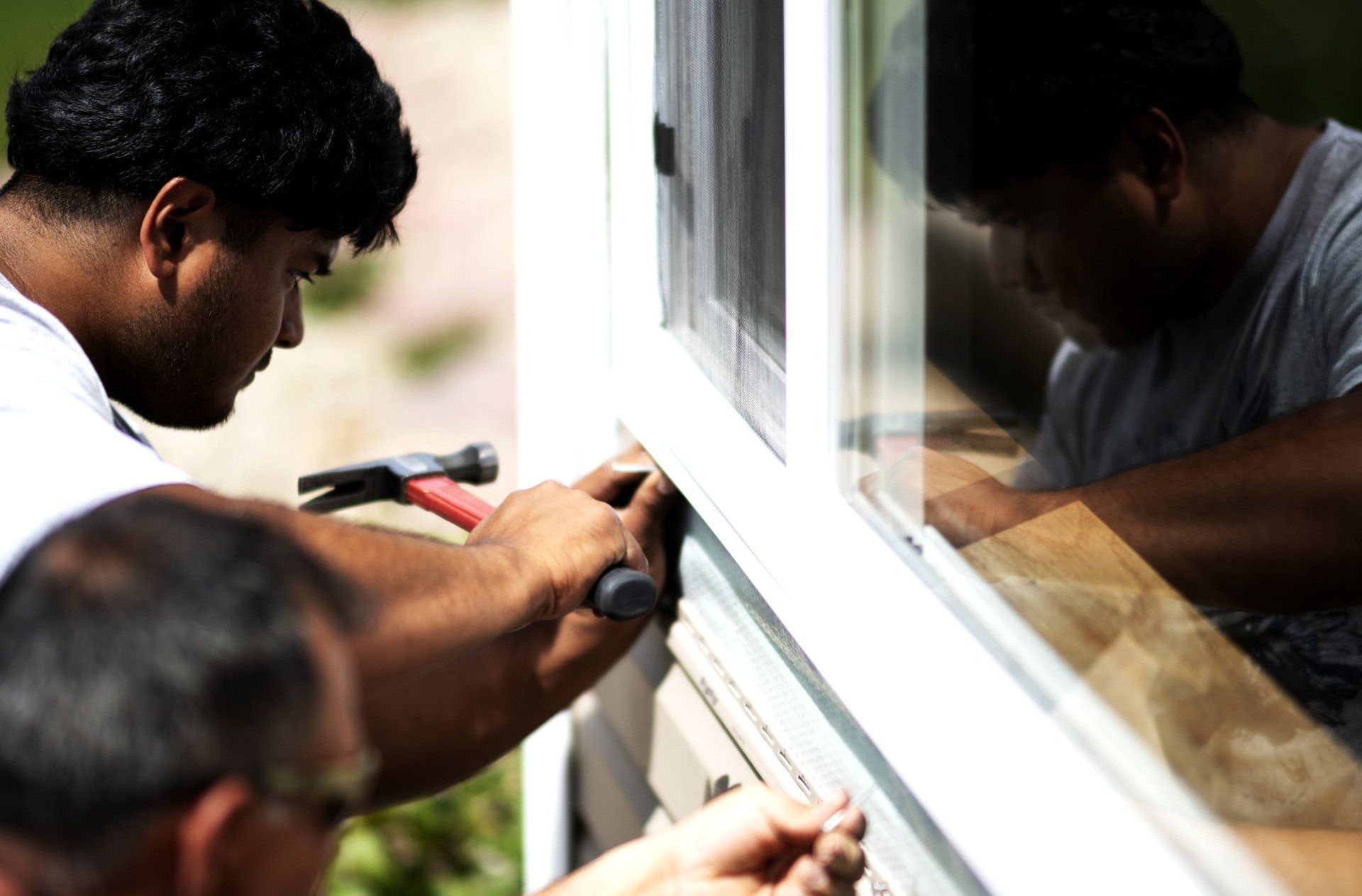 2 people working on exterior of home