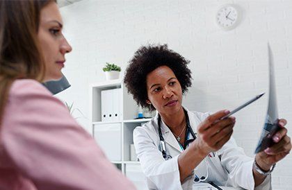 Doctor Talking with Patient at Desk — Key West, FL — Dr. Arthur J. Grizzle, M.D. Doctor Talking with Patient at Desk — Key West, FL — Dr. Arthur J. Grizzle, M.D.