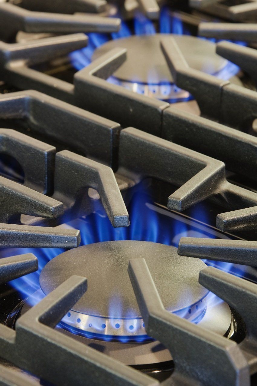 A close up of a gas stove with blue flames