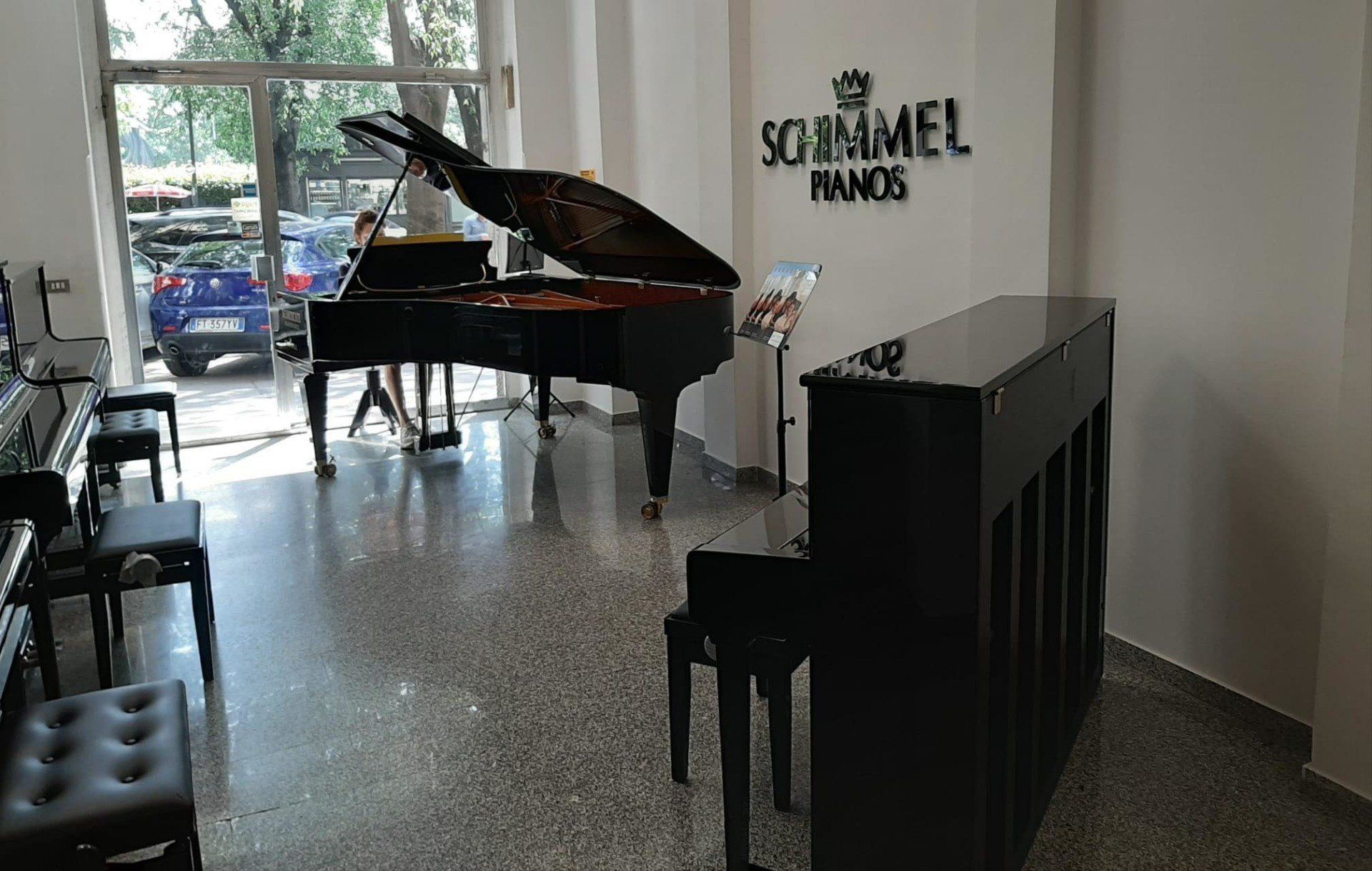 Una stanza con un pianoforte e un cartello che dice schimmel france