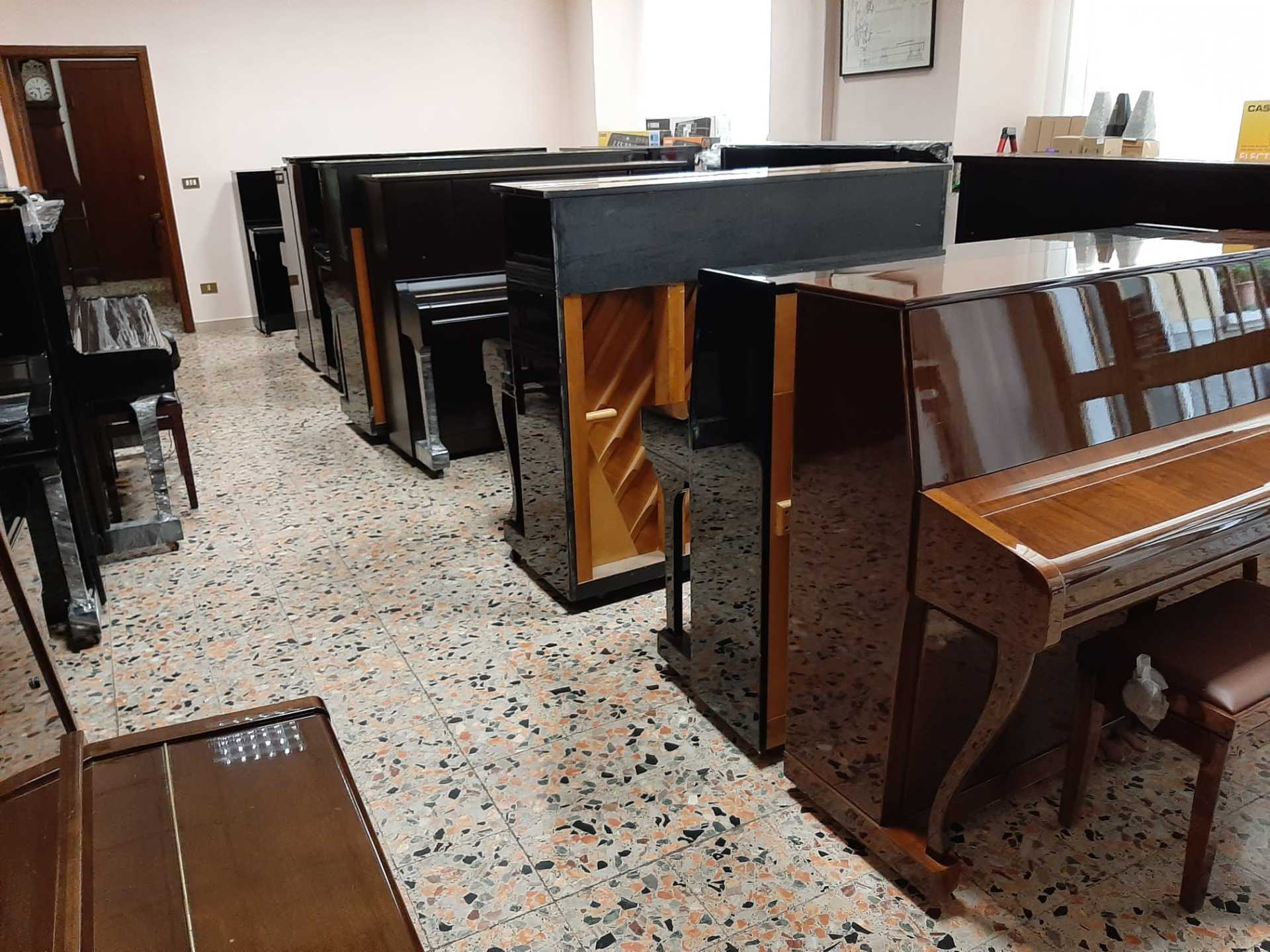 Una fila di pianoforti sono allineati in una stanza