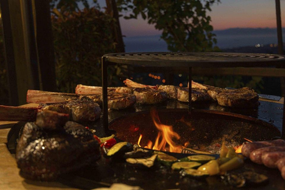 Carne e verdure grigliate sul fuoco al tramonto.