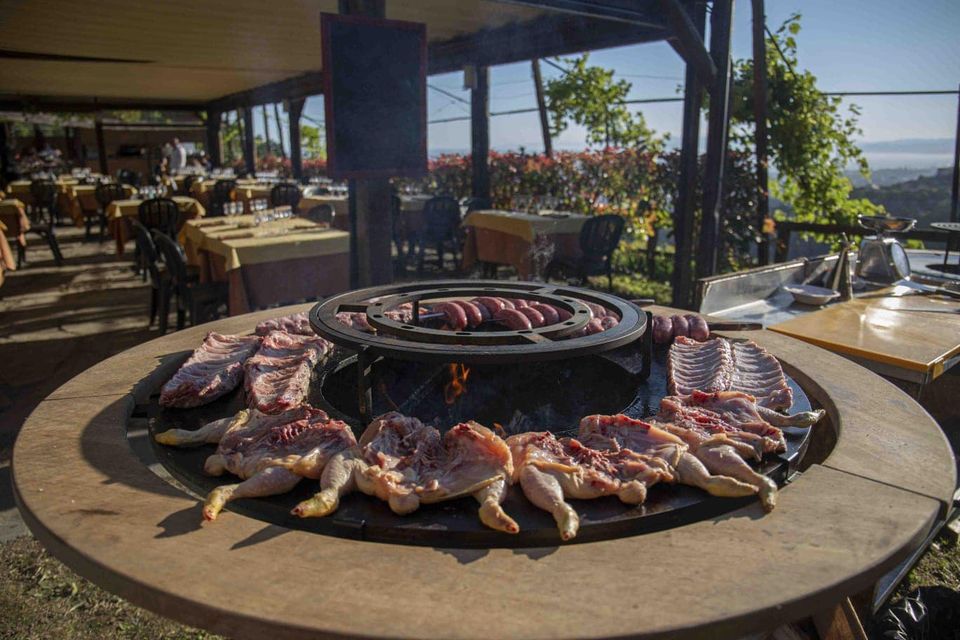 Grigliate di carne cruda e pollo in un ristorante all'aperto con vista panoramica.