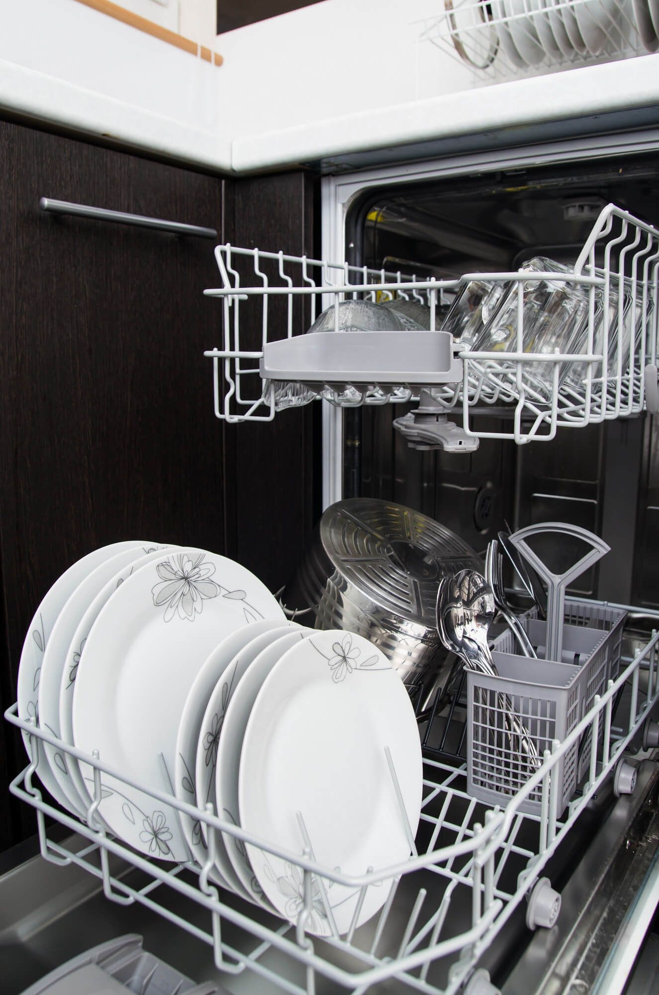 White plates lined up neatly in a clean dishwasher