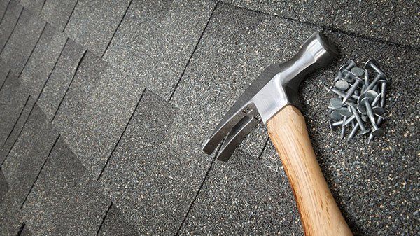 Residential Roofing — Hummer and Nails on a Roof in Baton Rouge, LA Residential Roofing — Hummer and Nails on a Roof in Baton Rouge, LA