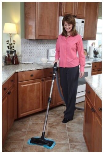 Woman Vacuum Cleaning the Kitchen — Baldwin, MD — JPI Services Woman Vacuum Cleaning the Kitchen — Baldwin, MD — JPI Services