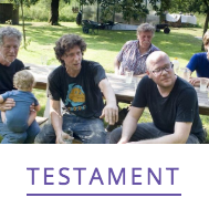 Een groep mensen zit samen aan een buitentafel met het woord 