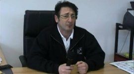 uomo vestito con tuta aziendale seduto nel suo ufficio
