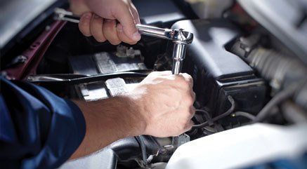 A mechanic working on a cars engine