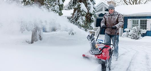 Man Removing Pile of Snow — Landscaping Services in West Lawn, PA Man Removing Pile of Snow — Landscaping Services in West Lawn, PA