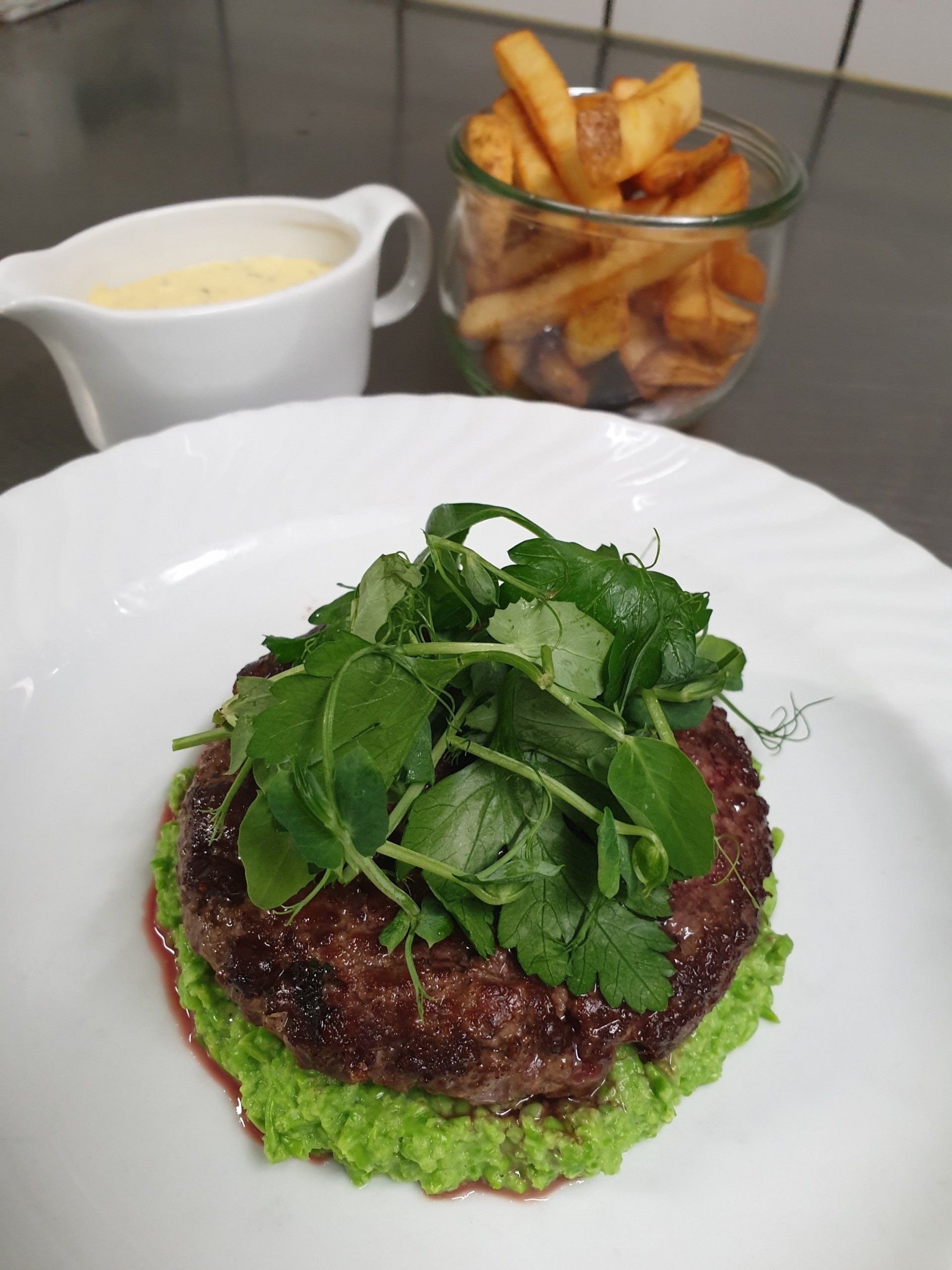 burger med grøn sauce og salat