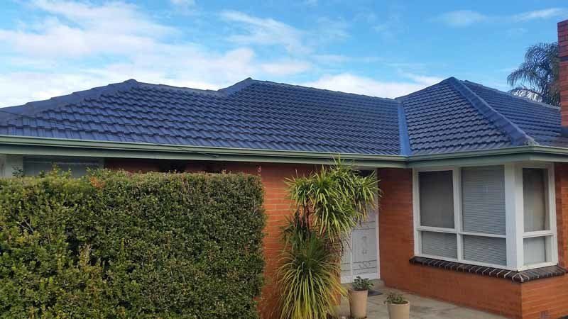 restored black roof on orange house