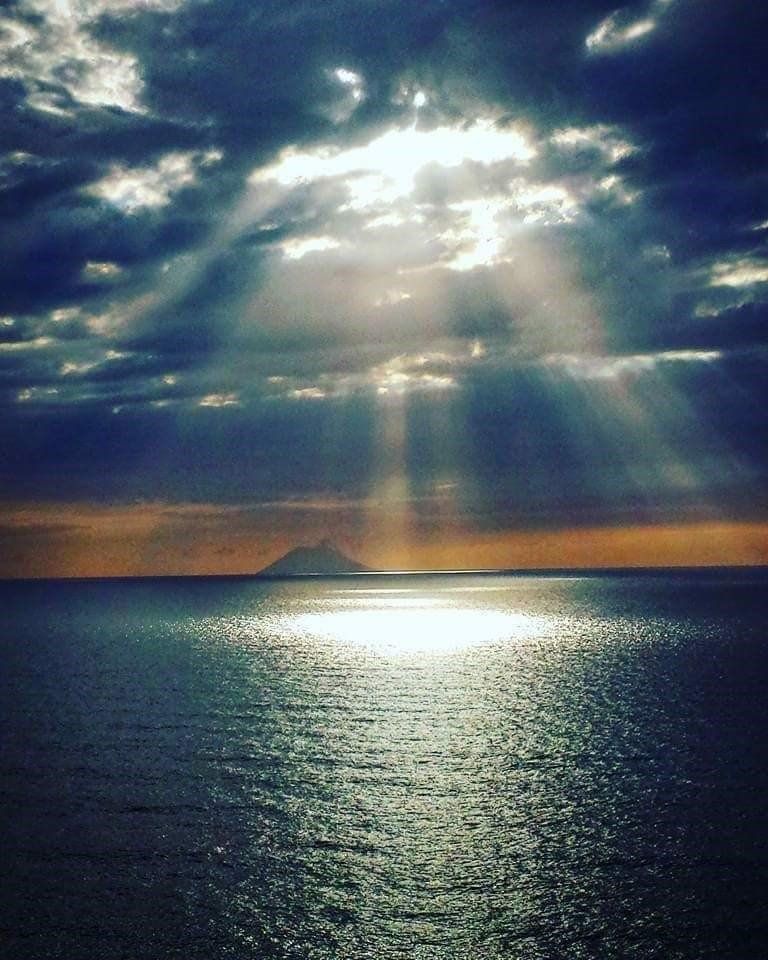 Il sole splende attraverso le nuvole sopra l'oceano
