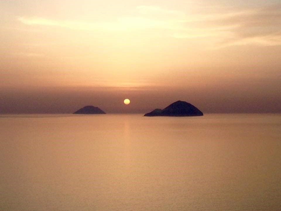 Due piccole isole in mezzo all'oceano al tramonto