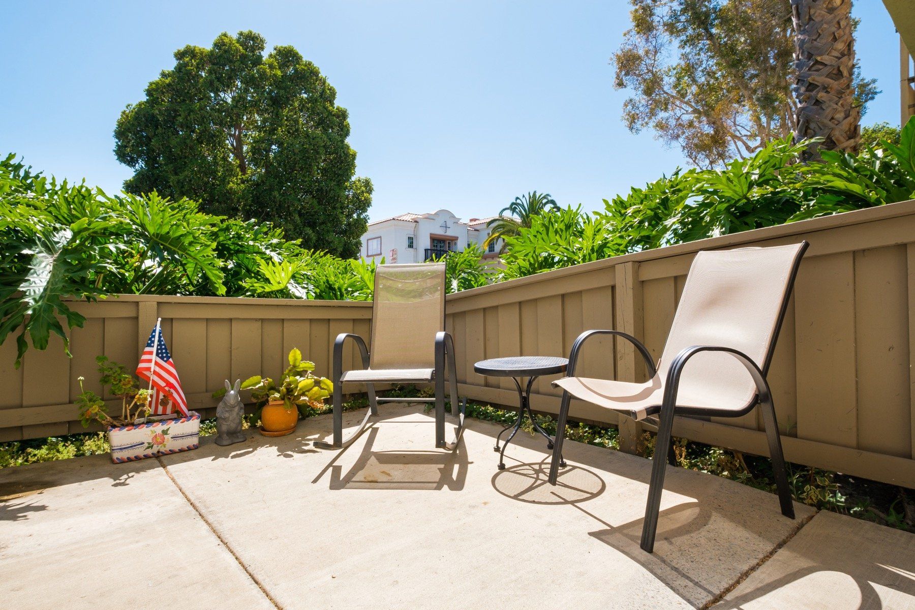 A patio with chairs , a table and an american flag