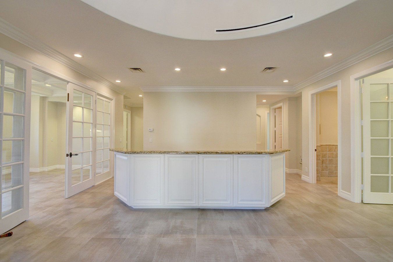 A large empty room with a white counter in the middle.