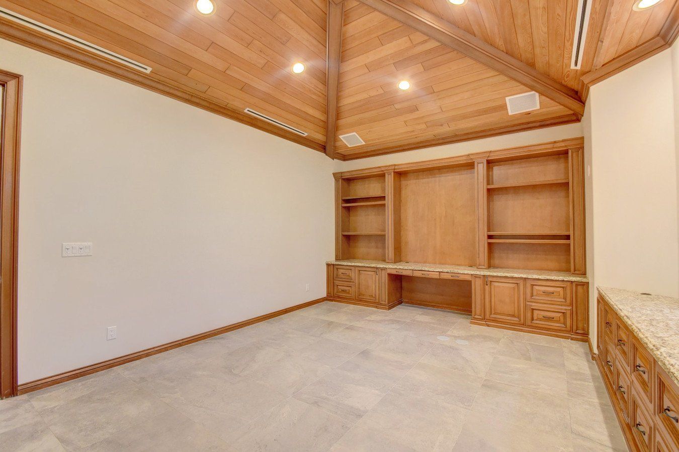 An empty room with wooden cabinets and a wooden ceiling.
