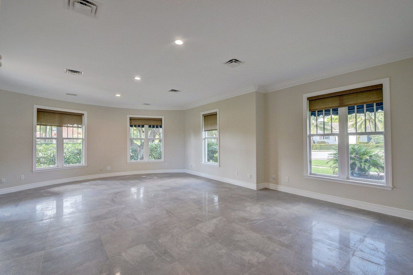 A large empty room with a lot of windows and a marble floor.