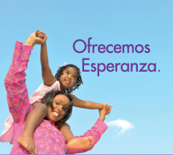 A woman is carrying a little girl on her shoulders with the words ofrecemos esperanza in the background