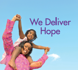 A woman is carrying a little girl on her shoulders with the words we deliver hope above them