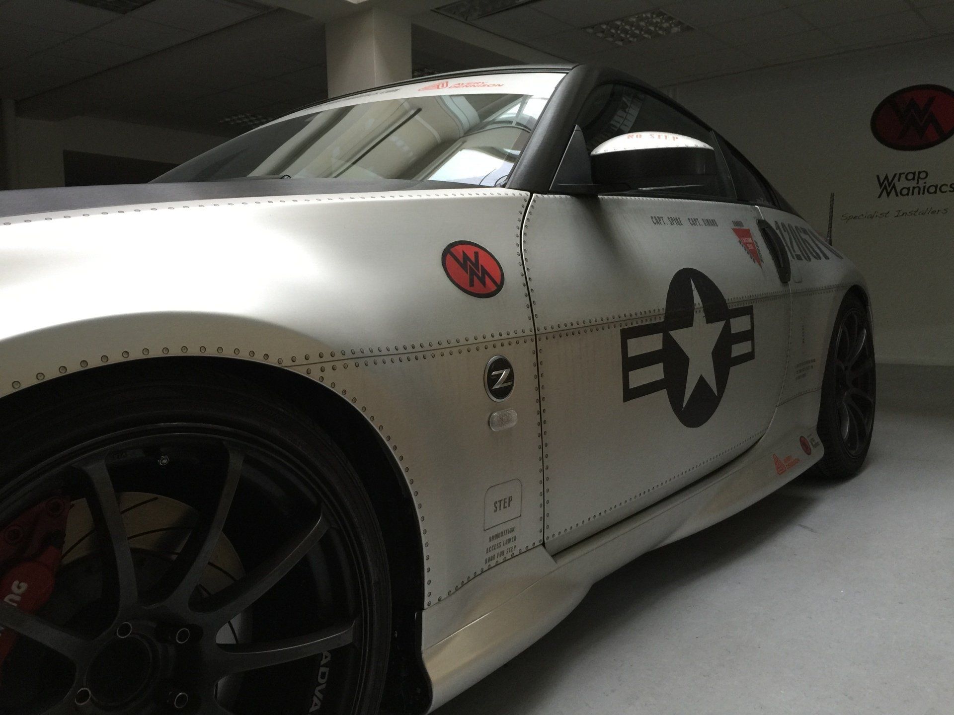 Wrapped Nissan 350Z Silver matte chrome sports car with warplane-inspired livery, including stars and insignia. Wrap Maniacs