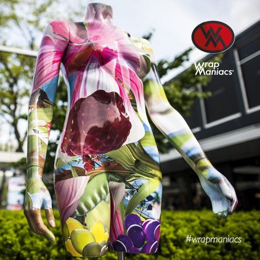 Mannequin with floral wrap artwork Markthal Rotterdam. stands outside; Wrap Maniacs logo in the corner.