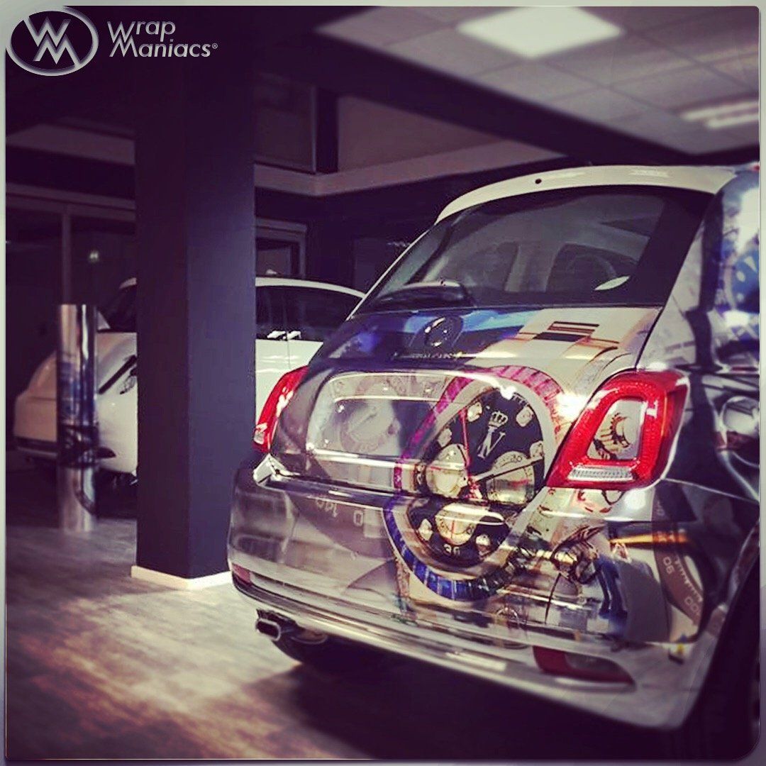 Rear view of a wrapped chrome Fiat 500 car with a complex graphic Rolex design inside Wrap Maniacs workshop.