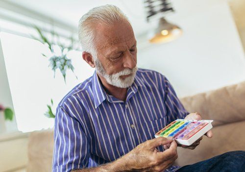 Senior Man Taking Pills at Home — Plano, TX — UBP Insurance Senior Man Taking Pills at Home — Plano, TX — UBP Insurance
