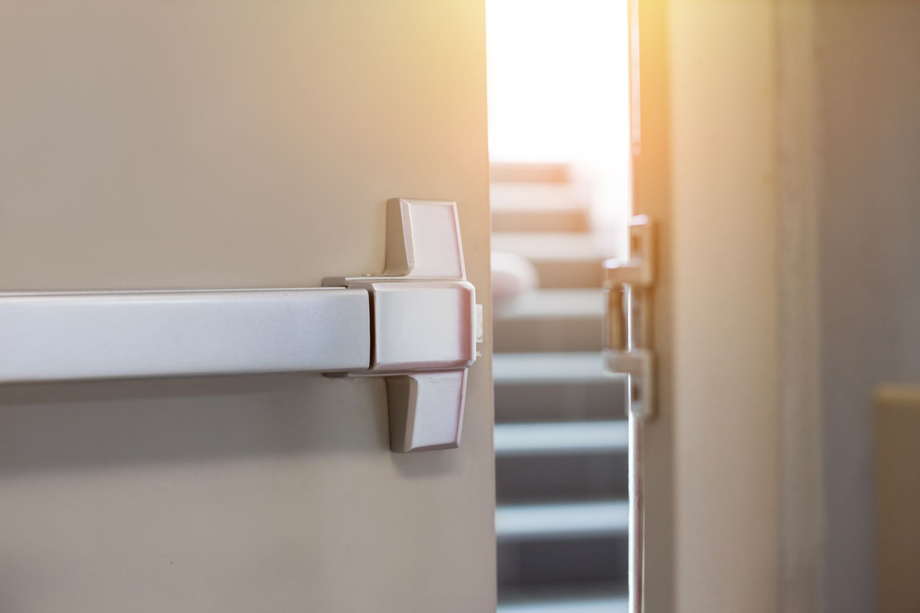 A close up of an open door with stairs in the background.