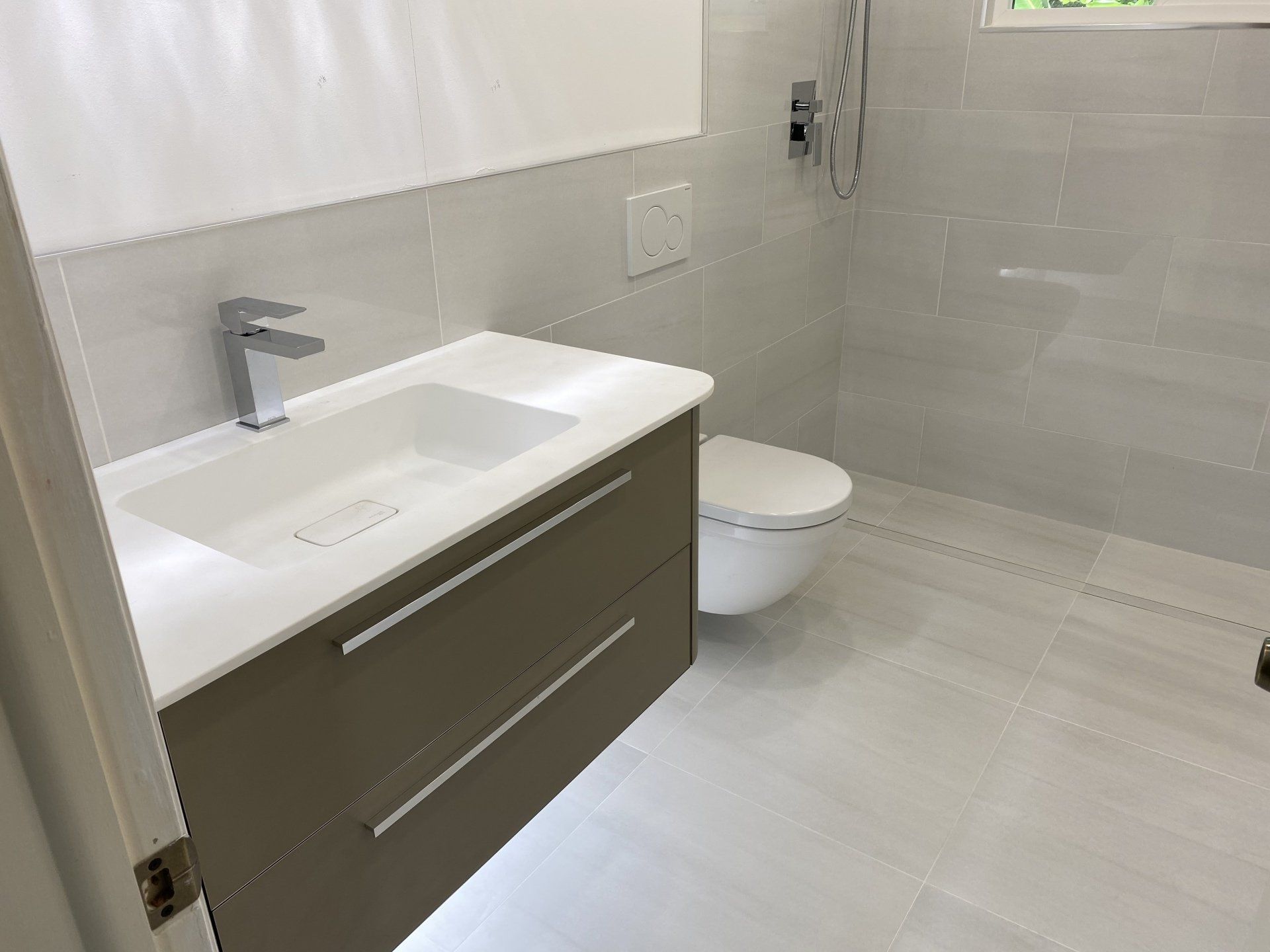 A bathroom with a sink , toilet and shower.
