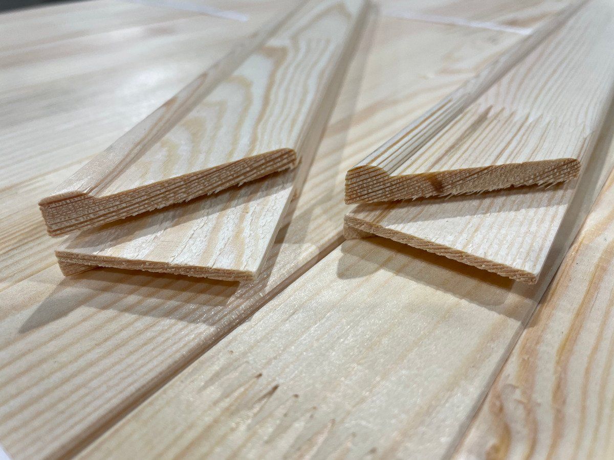 Two clear acrylic clips with wooden handles resting on a light wood surface