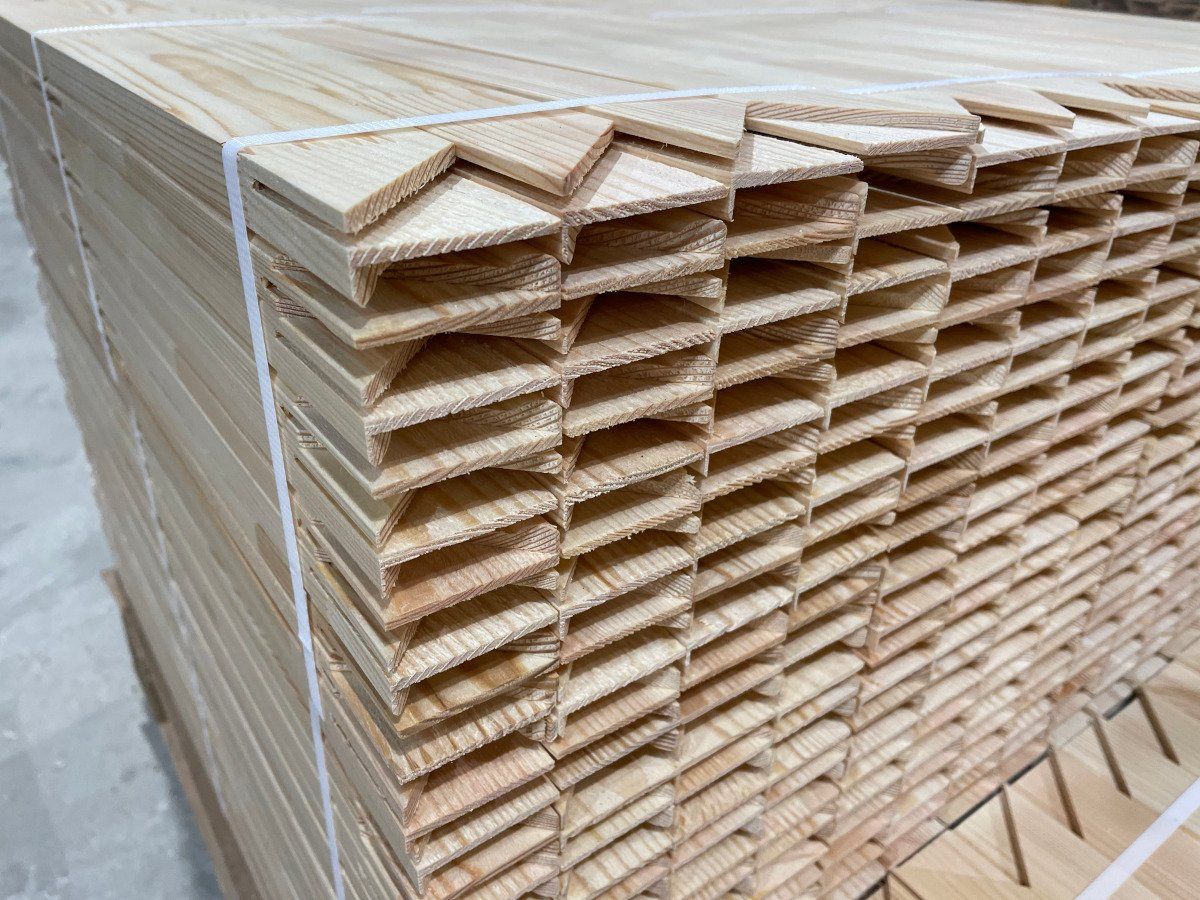 Stacked wooden planks bundled with straps in a storage area