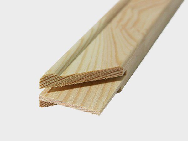 Two light-colored wooden trim boards stacked diagonally on a white background