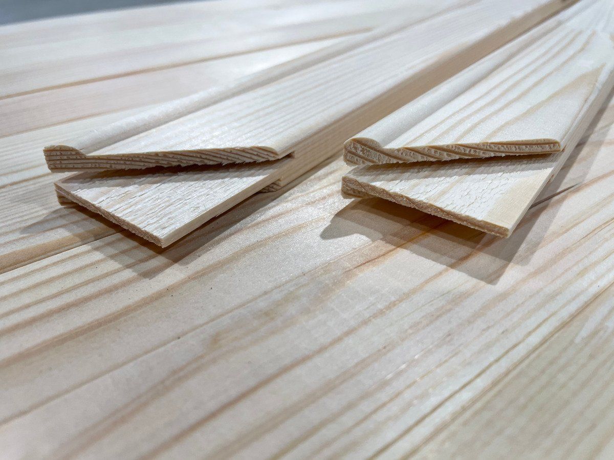Three wooden triangles on a light wood surface, arranged in two small pairs
